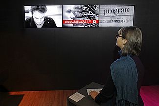 Besucherin steht vor dem Bildschirm an der Tastatatur